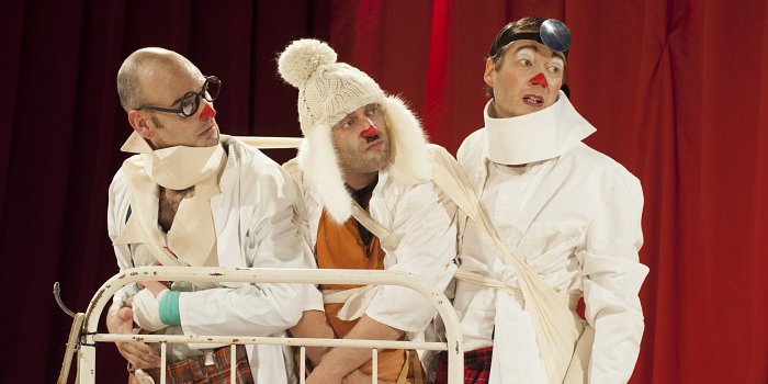 Drei Musiker auf Treppe und im Theaterzelt